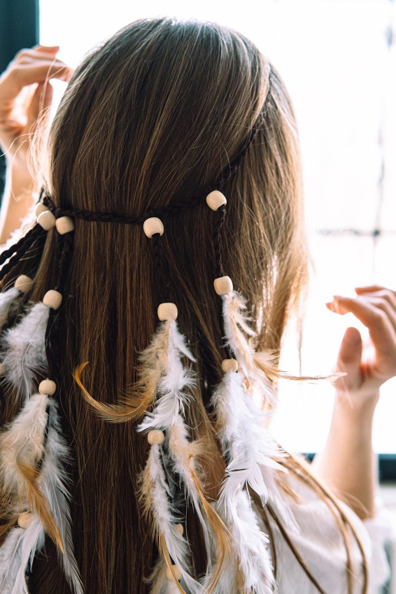 a woman with long brown hair with white beads